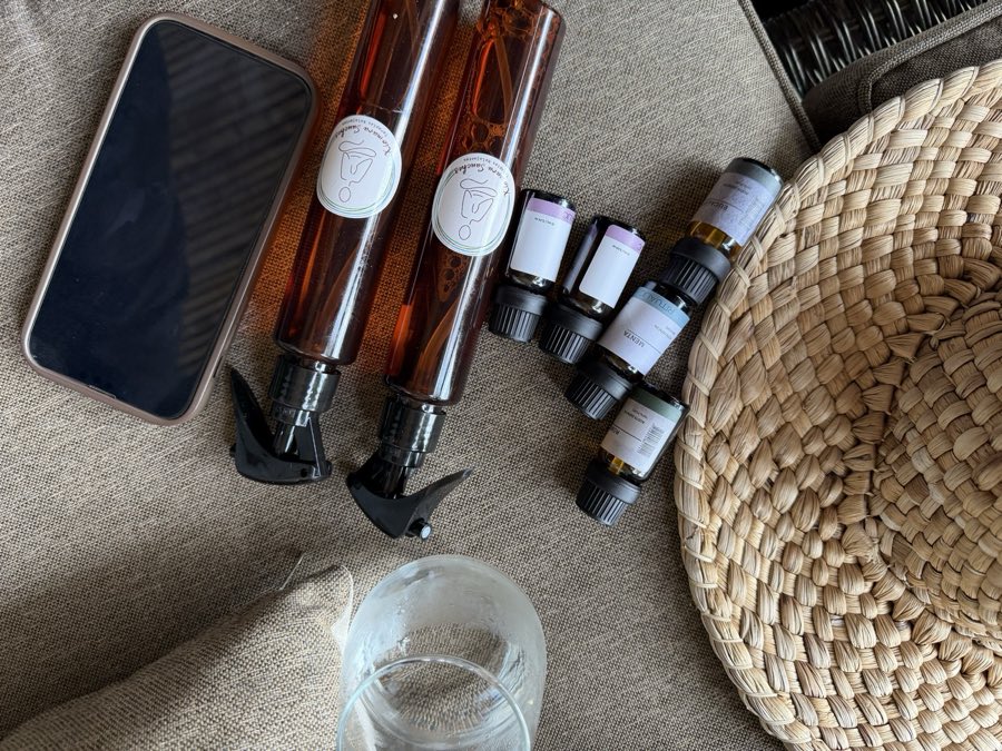 Frascos ámbar de aceites de masaje con dosificador, ordenados sobre una superficie tejida.