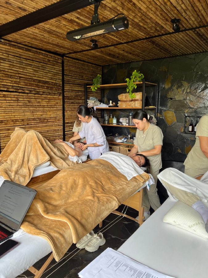 Espacio de terapia con aceites, textiles y material de trabajo organizado en estantería.